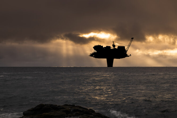 Oljeplattform til havs ved solnedgang. Foto