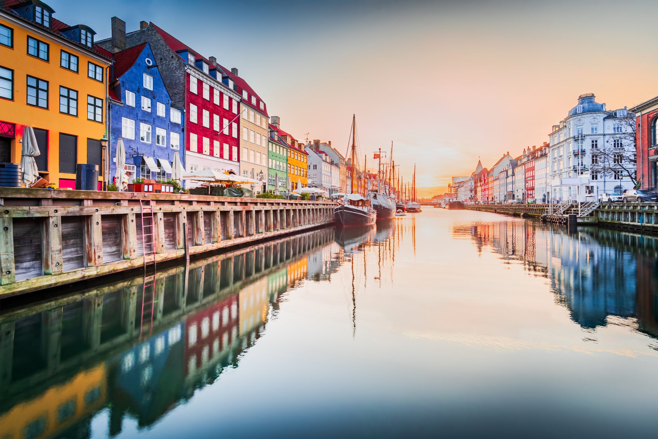 Sjarmen ved Nyhavn i København, Danmark. Ikonisk kanal, fargerik soloppgang og fantastiske vannspeilinger. Foto
