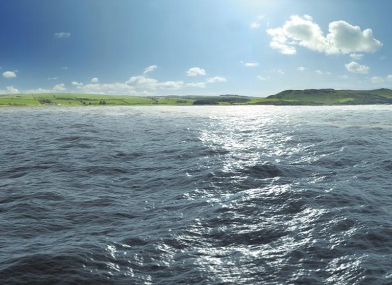 Bilde av sjø med land i bakgrunnen. Foto